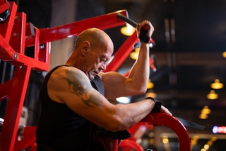 Kunde trainiert an der High Row Ruder Maschine.