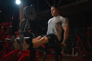 Kunde trainiert am Beinstrecker.