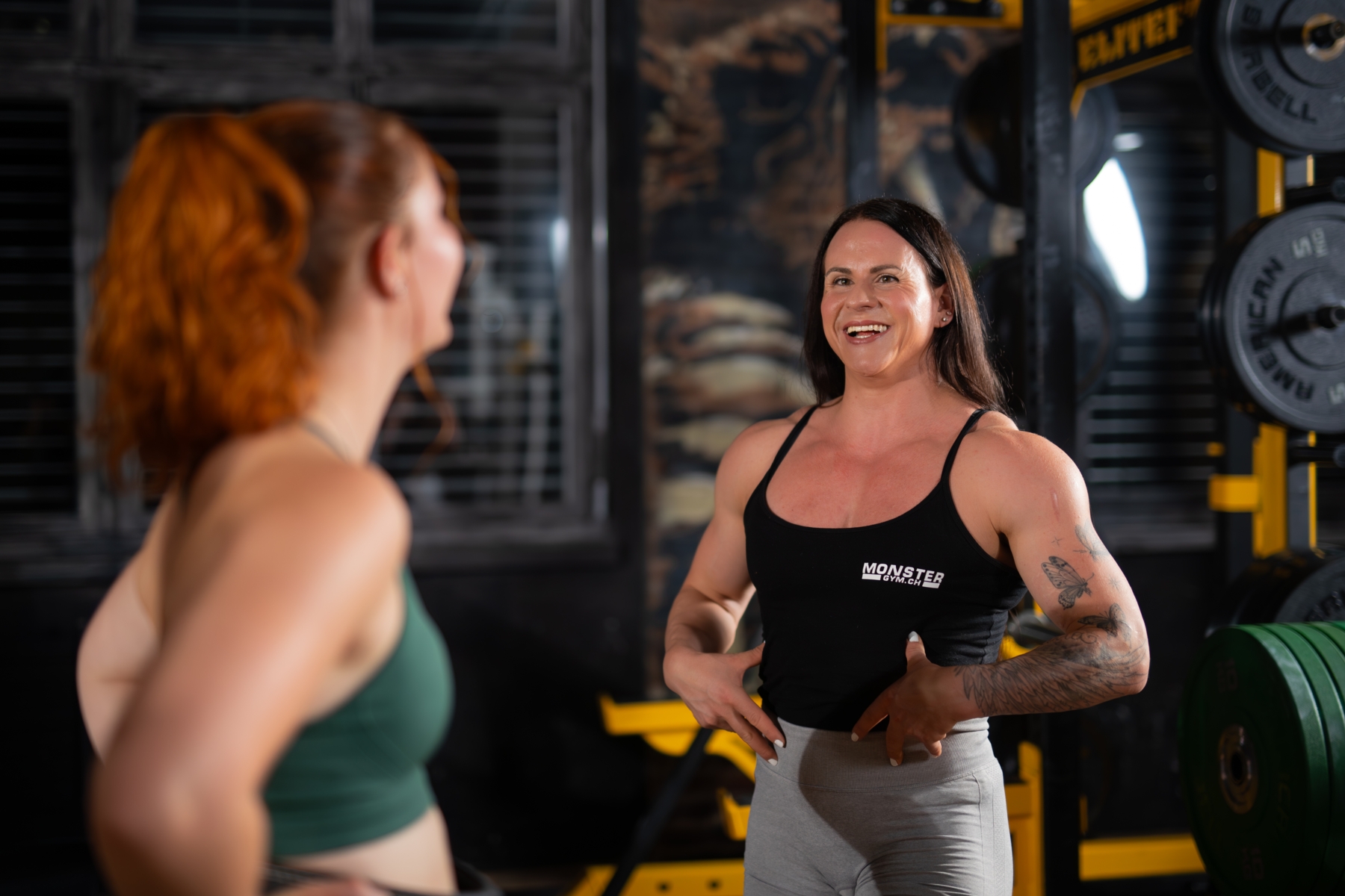 Trainerin zeigt Kundin eine Technik zum Kreuzheben.