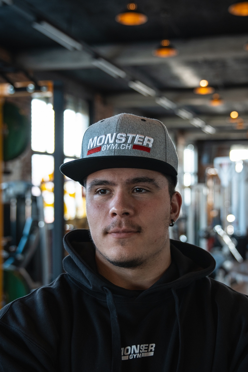 Sportler trägt die monster-gym.ch Cap, Frontansicht.