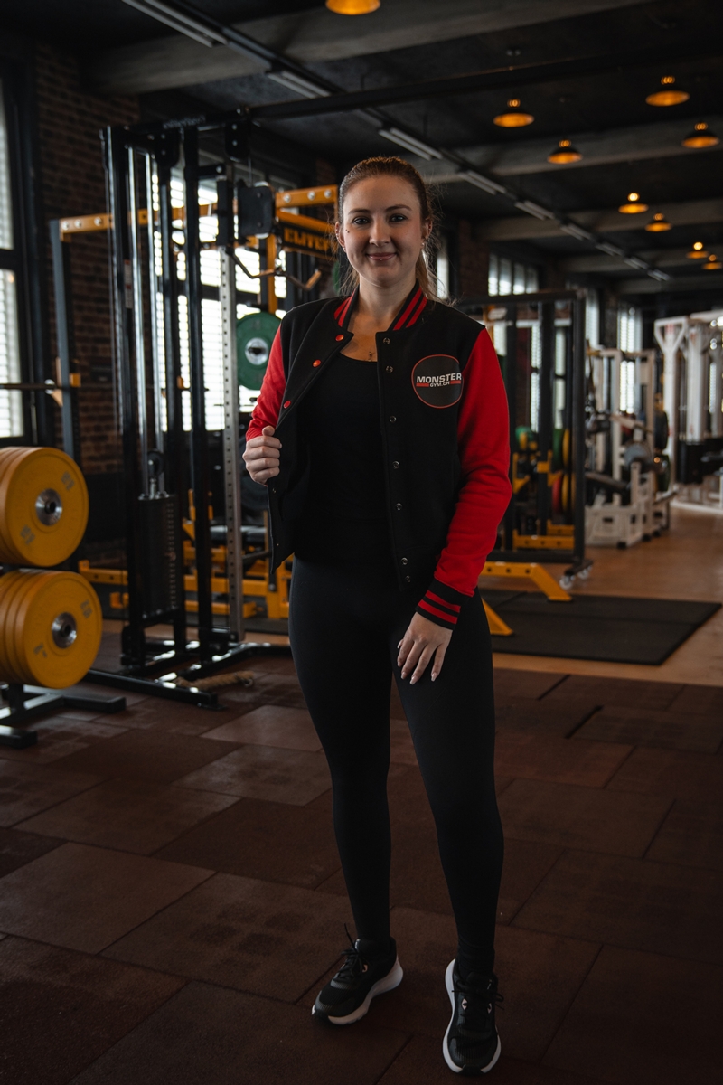 Sportlerin mit College Jacke in Frontansicht.