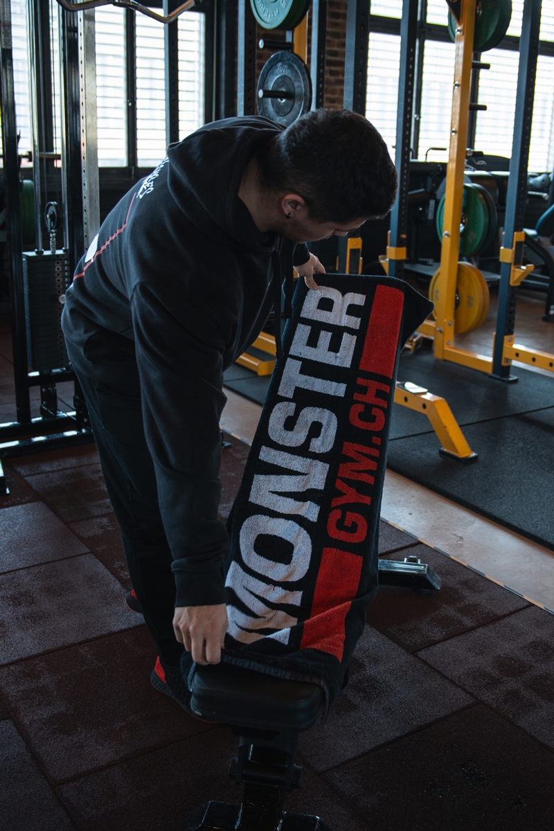 Trainierender platziert sein monster-gym.ch Trainingstuch auf einem Kraftgerät.
